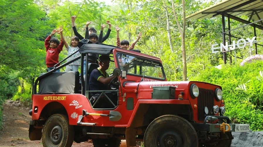 Group celebrating on a red jeep during a forest tour at Holistic Eco-Resort