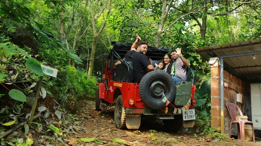 People riding a red jeep through the jungle forest at Holistic Eco-Resort