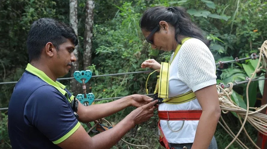 Guides preparing zipline harness in the forest at Holistic Eco-Resort