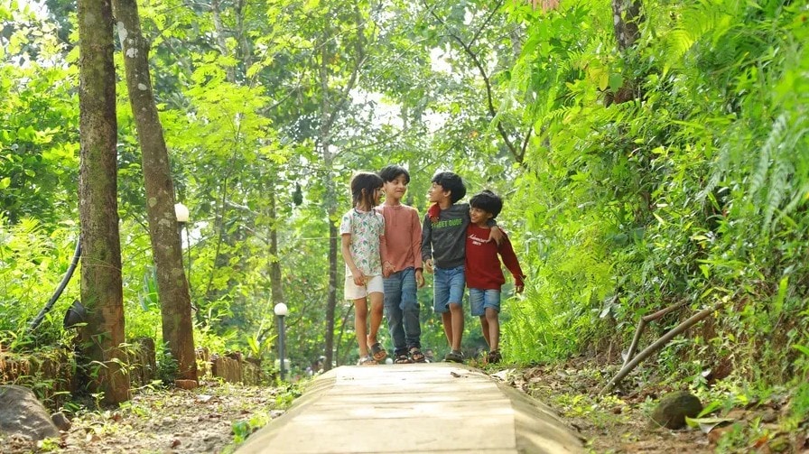 Four children walking together along a jungle path at Holistic Eco-Resort