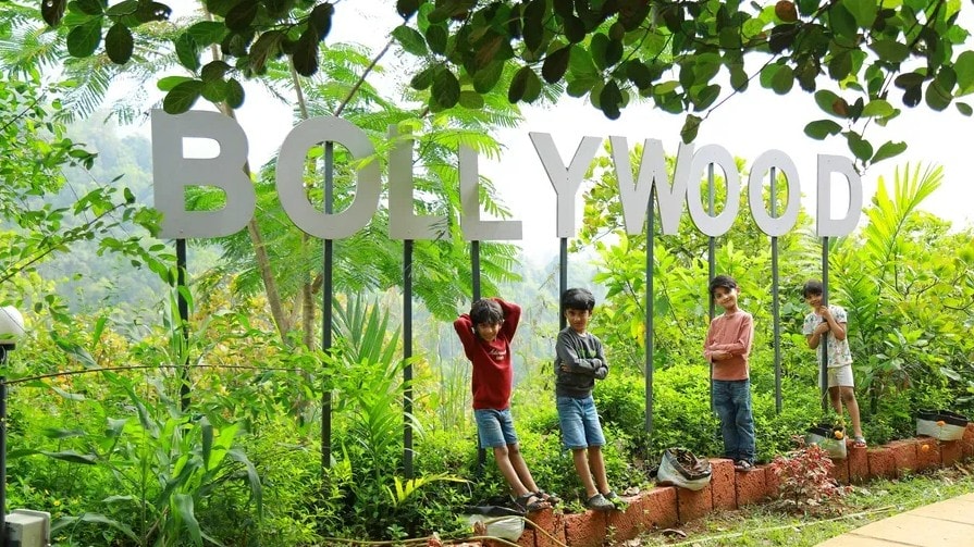 Children posing in front of the Bollywood sign in the garden at Holistic Eco-Resort
