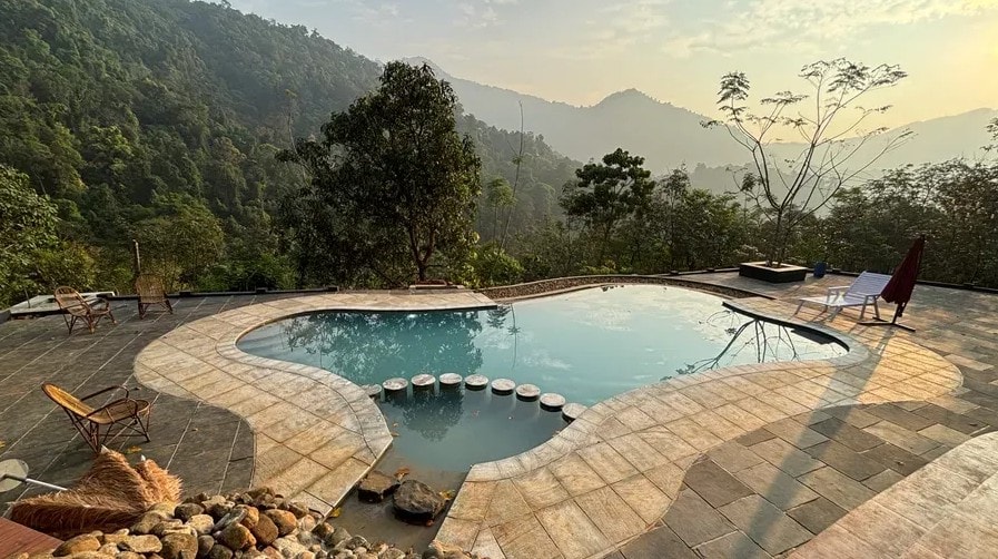 Resort pool with mountain and forest views at golden hour at Holistic Eco-Resort