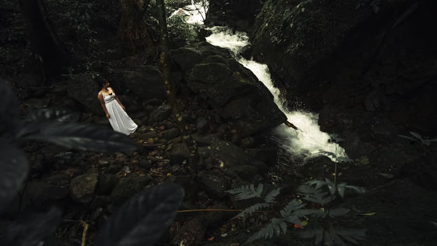 Lady at the private waterfall in the forest canyon