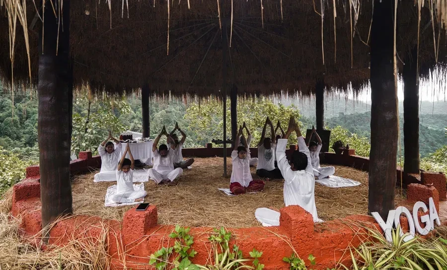 Group yoga class at the thatched hilltop pavilion